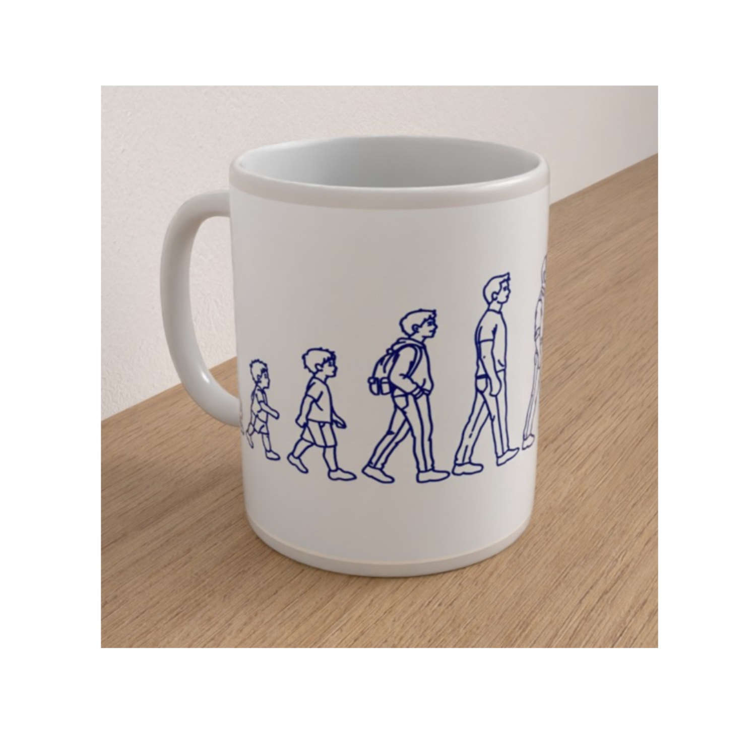 White ceramic Manhood mug featuring blue line drawings of a boy growing from childhood into adulthood.