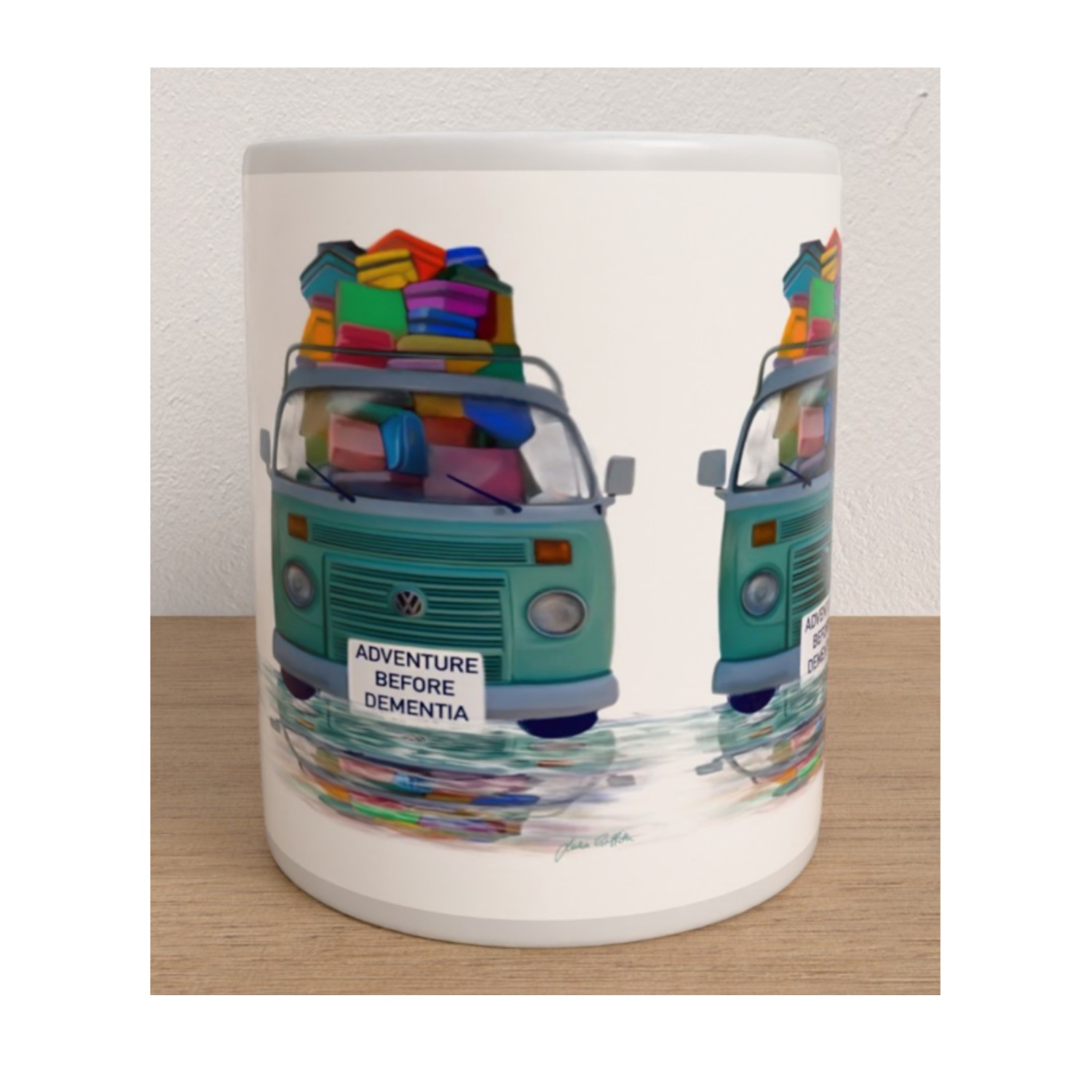 Front view of the Adventure Before Dementia mug featuring two turquoise campervans piled high with colourful luggage.