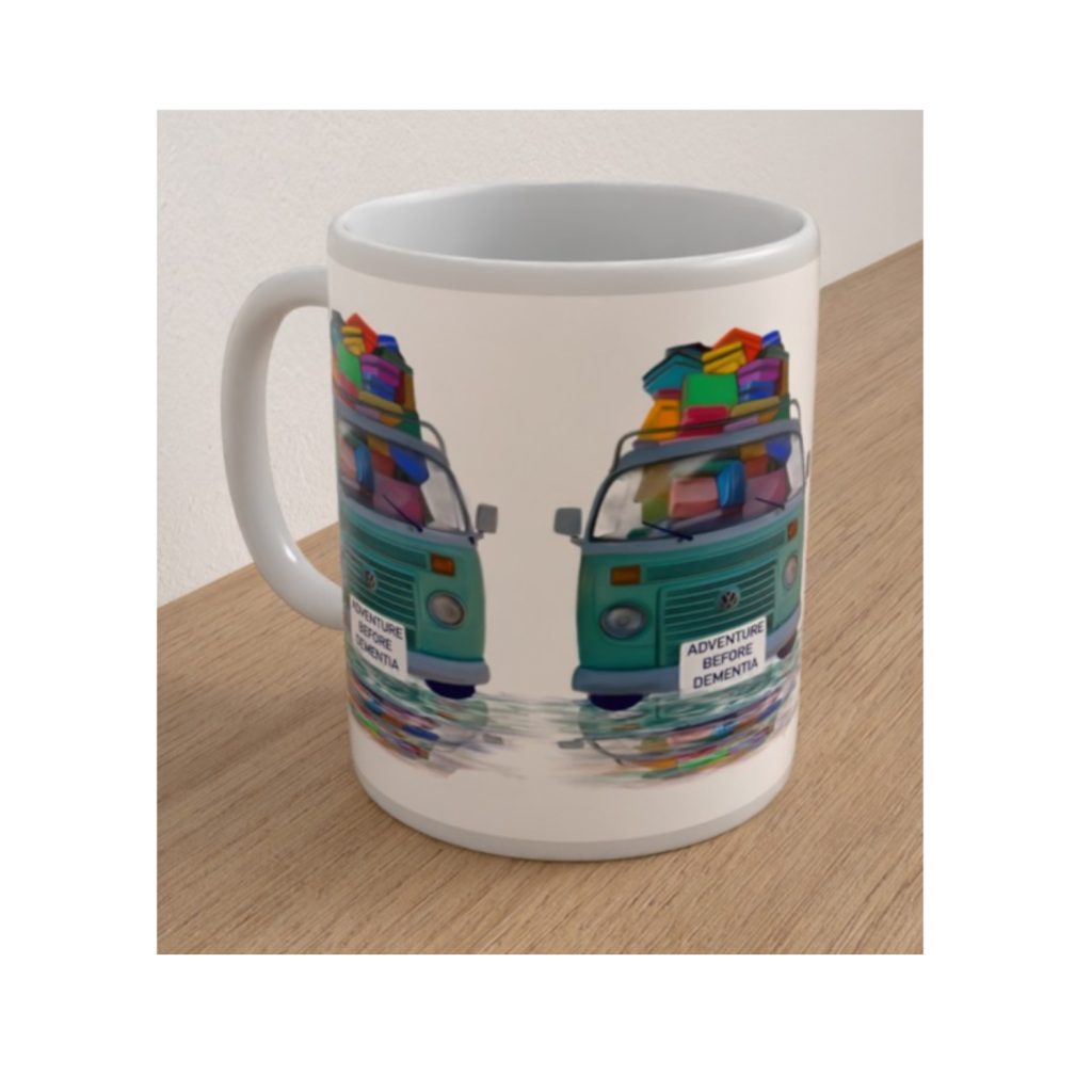 Angled view of the Adventure Before Dementia ceramic mug showing turquoise campervans loaded with colourful holiday luggage.