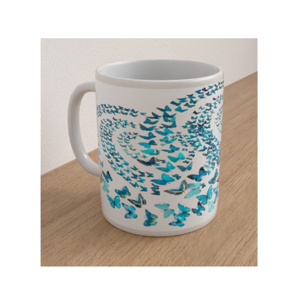 Angled white ceramic mug featuring a swirling pattern of blue and turquoise butterflies in different sizes.