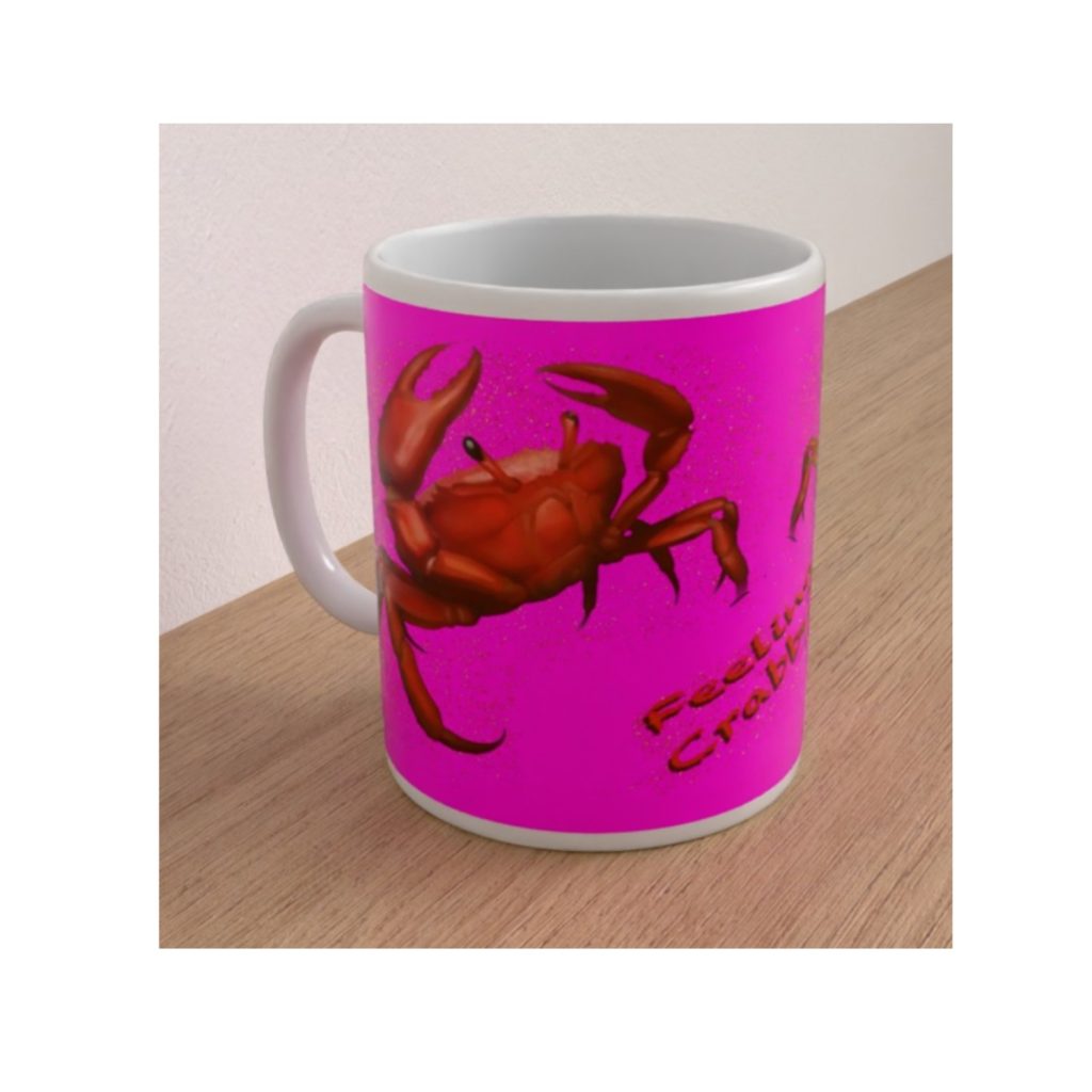 Angled view of the Crabby ceramic mug showing a large red crab and Feeling Crabby? lettering against a vivid pink background.