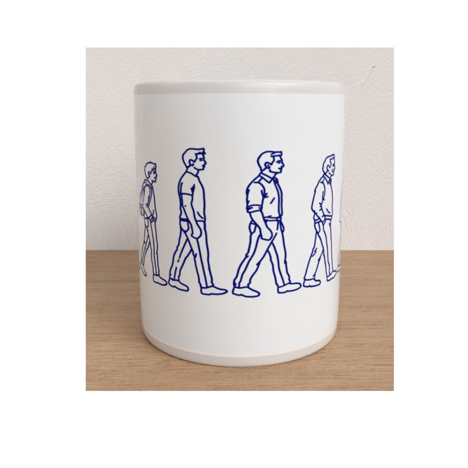 Front view of the Manhood ceramic mug featuring blue line illustrations of a man walking through different stages of adulthood.