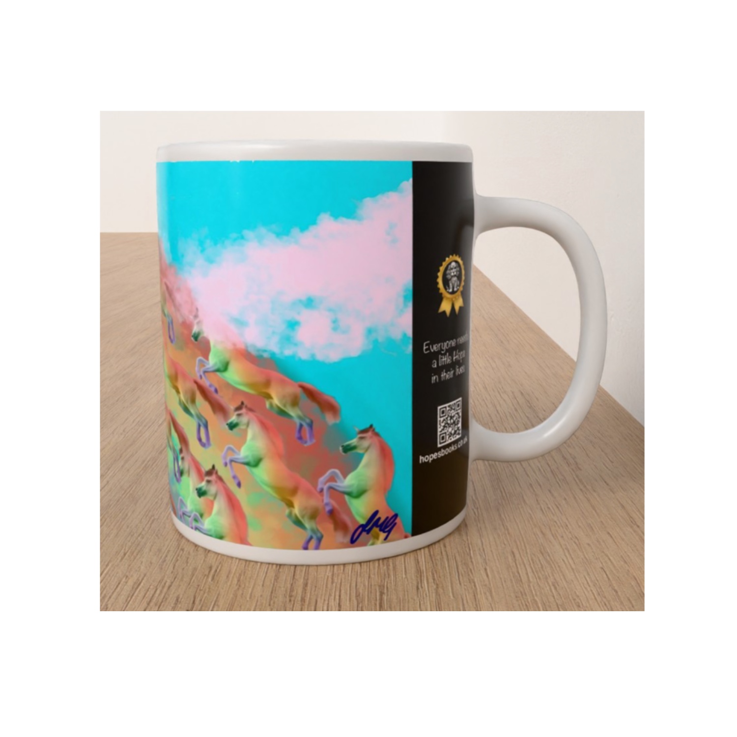 White ceramic Rainbow Horses mug featuring Julia Griffith's colourful artwork of galloping horses beneath a pink sky, photographed from the side.
