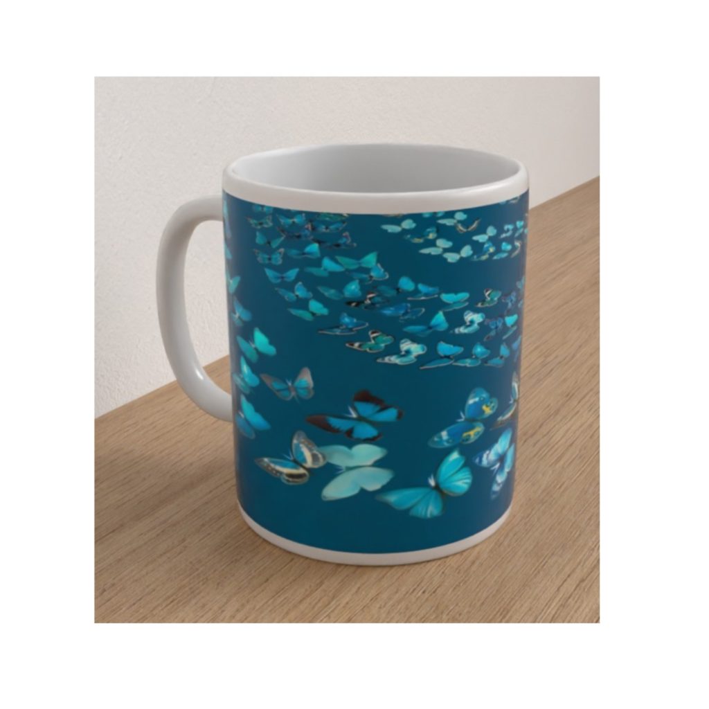 Angled view of the Teal Butterflies ceramic mug featuring blue and turquoise butterflies scattered across a rich teal background.