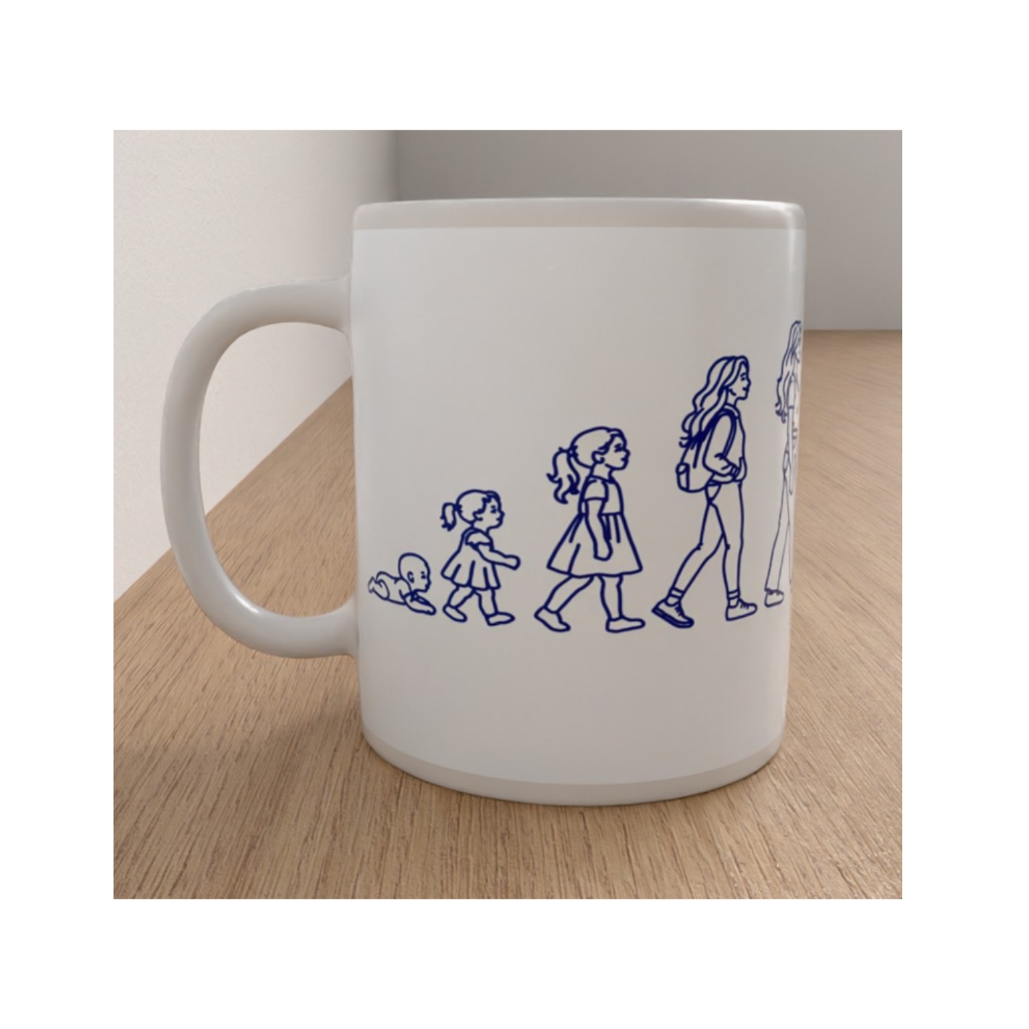 White ceramic Womanhood mug featuring blue line drawings showing the stages of a woman's life from babyhood to adulthood.